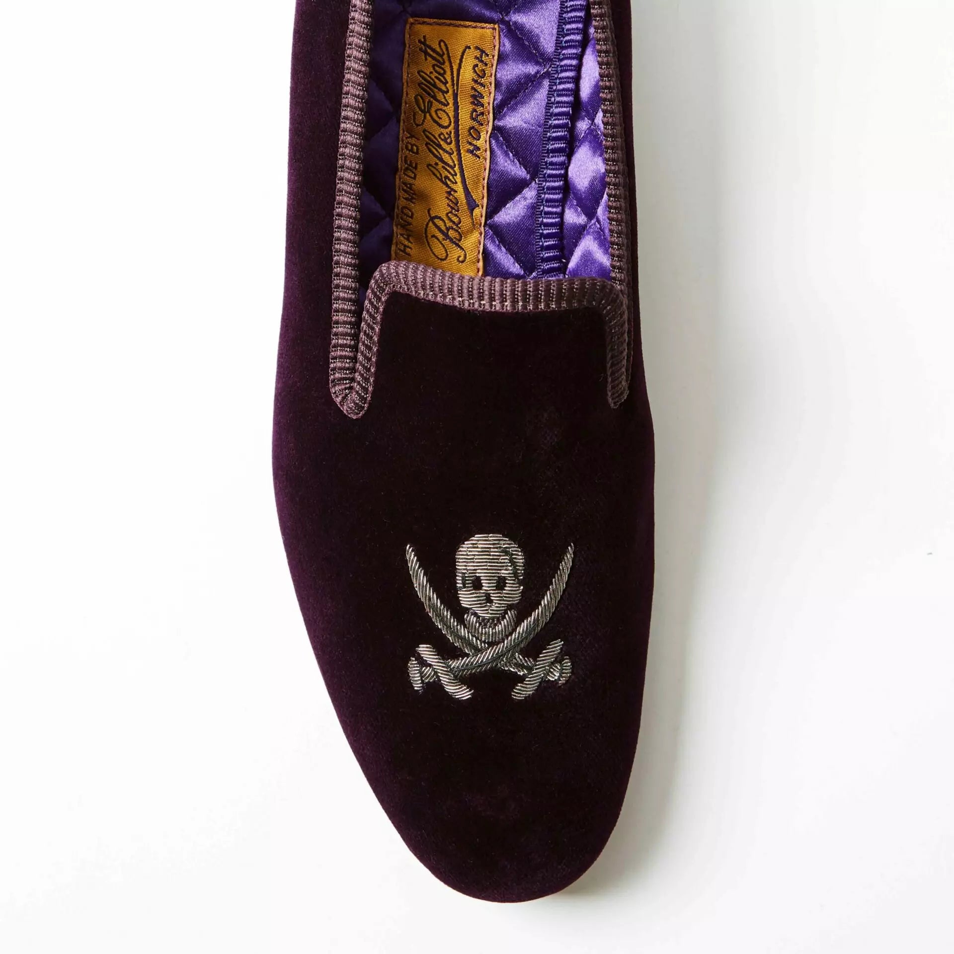 Purple Bowhill and Elliott velvet Albert slippers embroidered with skulls and crossed swords at Waring Tuxedos in Fort Worth.