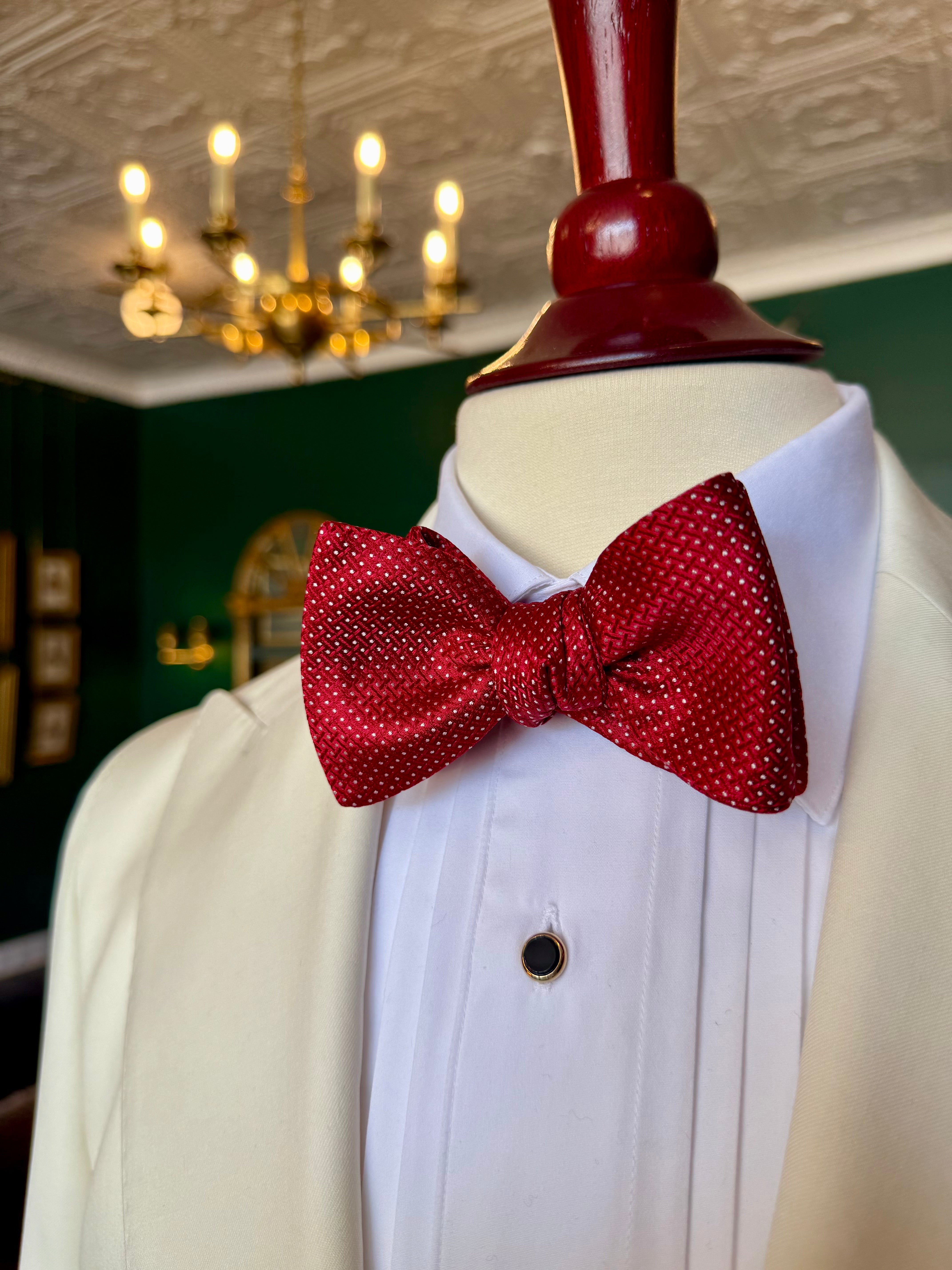 Red Runnymede Bow Tie from Waring Collection at Waring Tuxedos in Fort Worth, displayed on mahogany mannequin.
