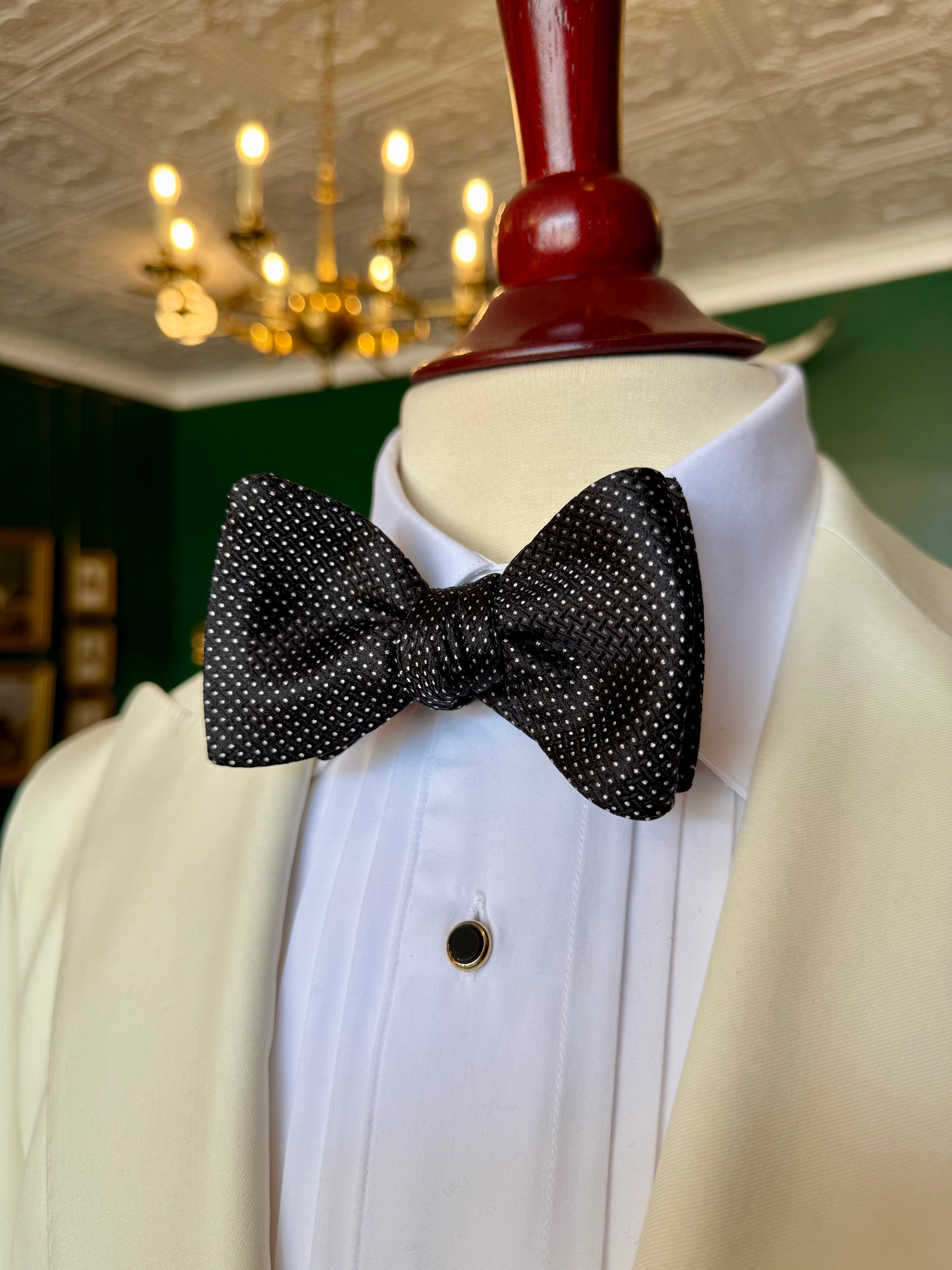 Black Runnymede Bow Tie from Waring Collection at Waring Tuxedos in Fort Worth, displayed on mahogany mannequin.