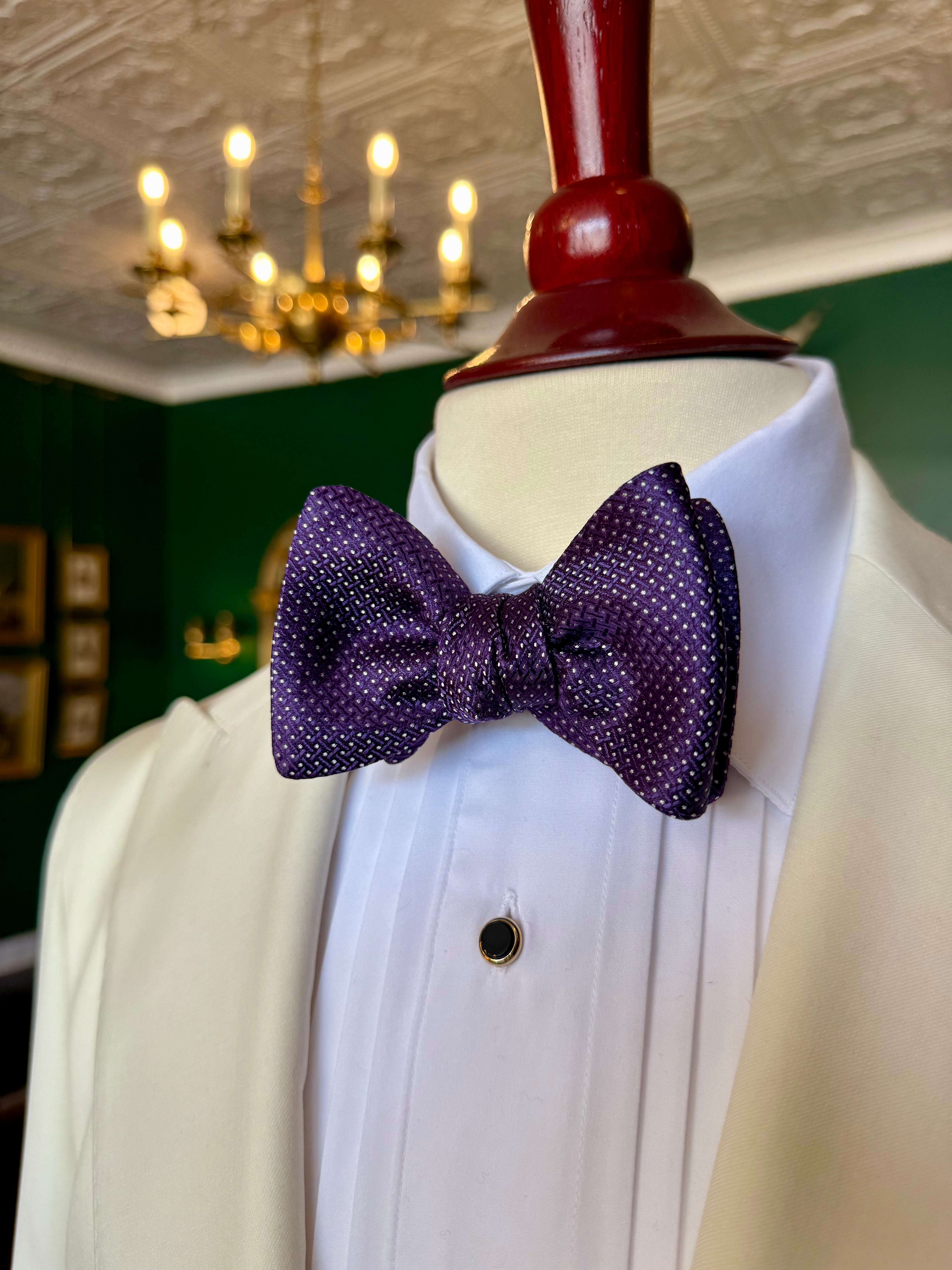 Purple Runymede Bow Tie from Waring Collection at Waring Tuxedos in Fort Worth, displayed on mahogany mannequin.