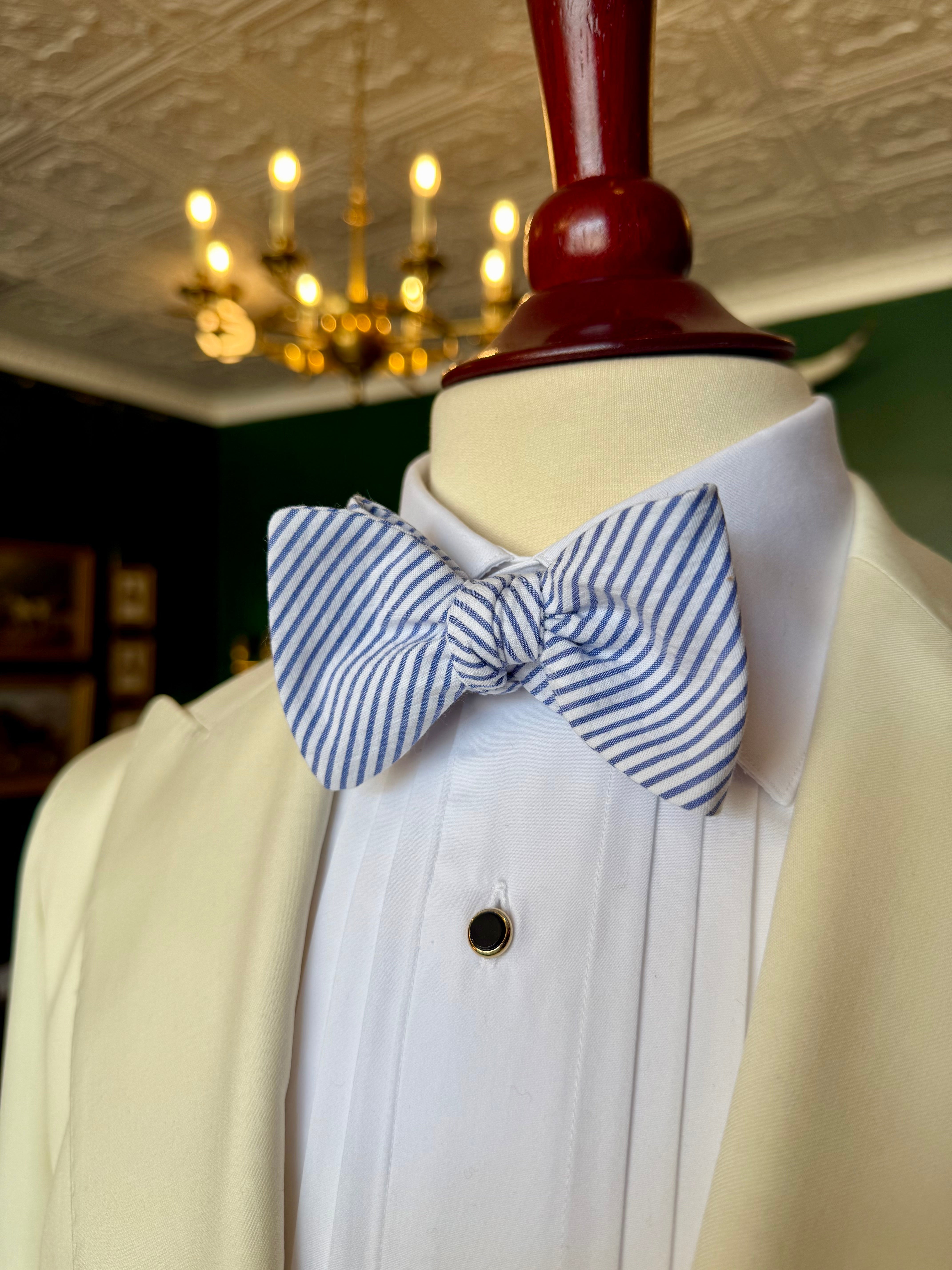 Seersucker Bow Tie from Waring Collection at Waring Tuxedos in Fort Worth, displayed on mahogany mannequin.